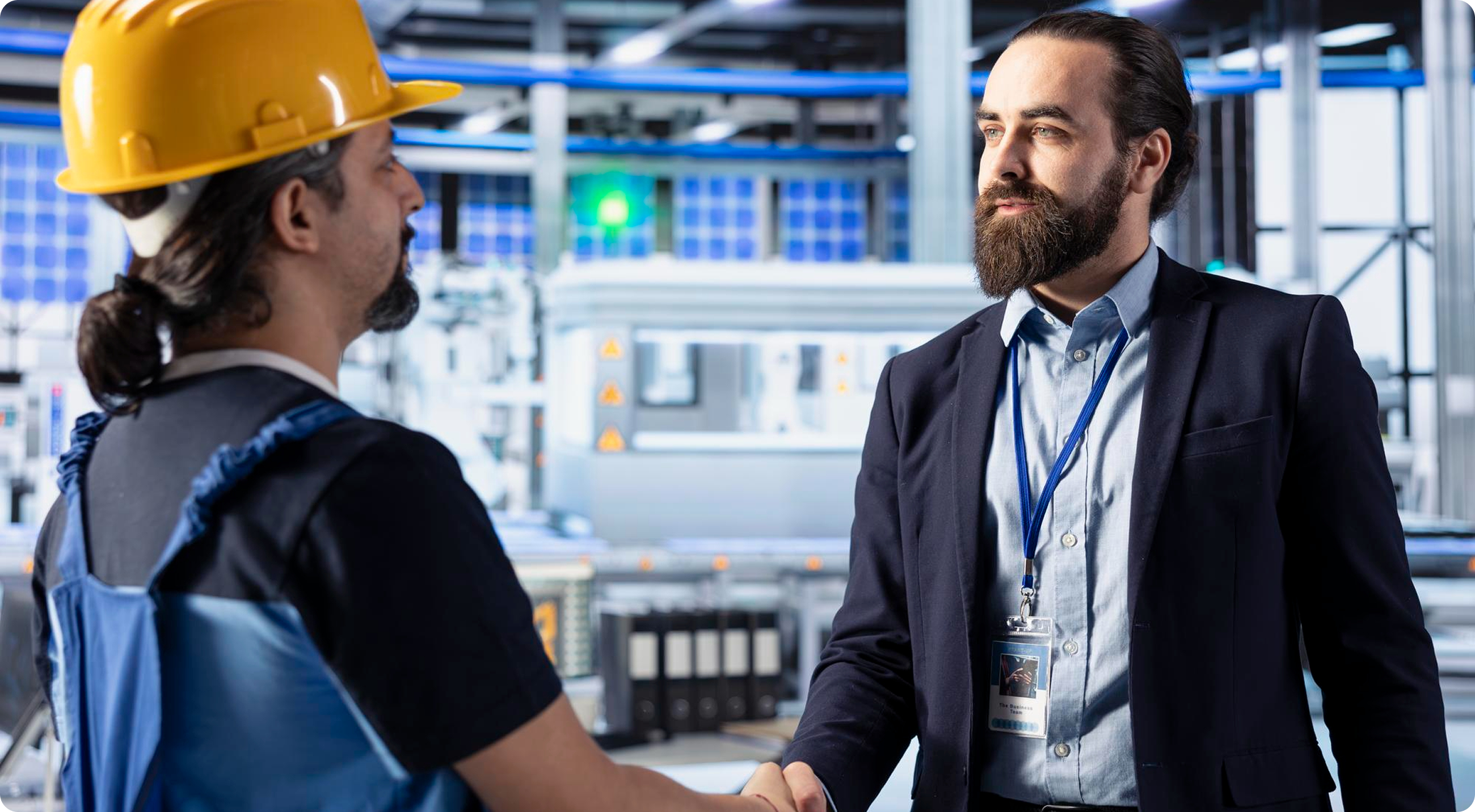 Business partner shaking hands with factory worker